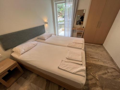 a bedroom with two beds and a window at Neapolis Apartments in Palaiochora