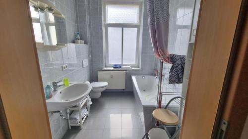 a bathroom with two sinks and a tub and a toilet at Apartment Karin in Dresden