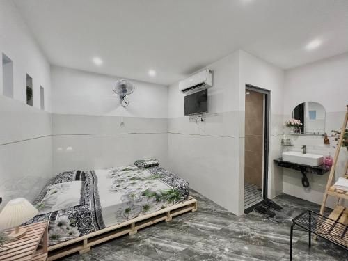 a bedroom with a bed and a sink at Nhà nghỉ IZUMI Phương Trang in Vung Tau