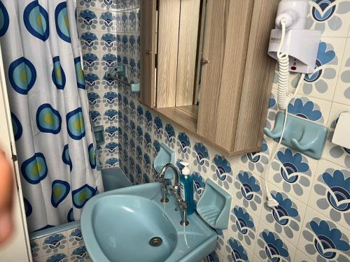 a bathroom with a blue sink and a cabinet at Neapolis Apartments in Palaiochóra