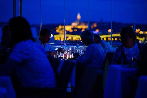 a group of people sitting at a table with wine glasses at Vogue Boat Apartments in Budapest