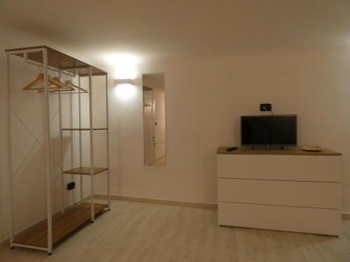 a room with a television on a dresser with a mirror at CASA SIMONETTA in Bari