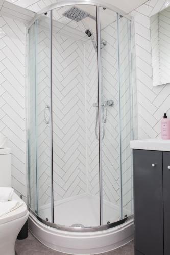a shower with a glass enclosure in a bathroom at Designer Cardiff Apartments in Cardiff