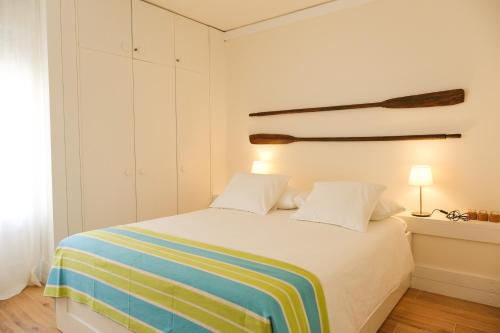um quarto com uma cama com um cobertor listrado colorido em Troia Beach and Nature - Apartment em Tróia