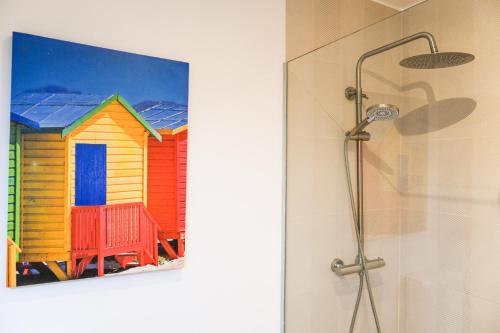 a painting of a colorful house in a bathroom at Troia Beach and Nature - Apartment in Troia