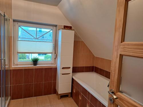 a bathroom with a bath tub and a window at Ferienwohnung am Nordstrand 2 in Alt Schwerin