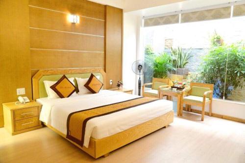 a bedroom with a large bed and a large window at Ánh Dương Hotel Hải Phòng in An Khê