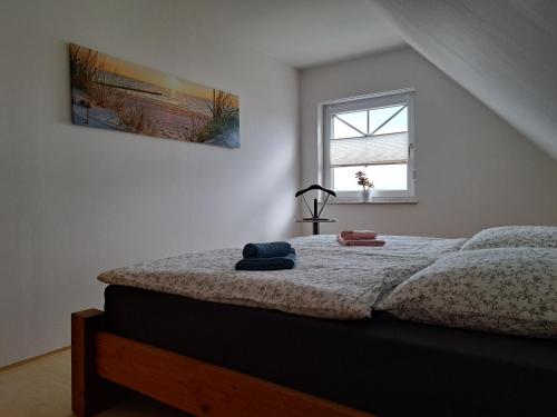 a white bedroom with a bed with a window at Ferienwohnung am Nordstrand 2 in Alt Schwerin