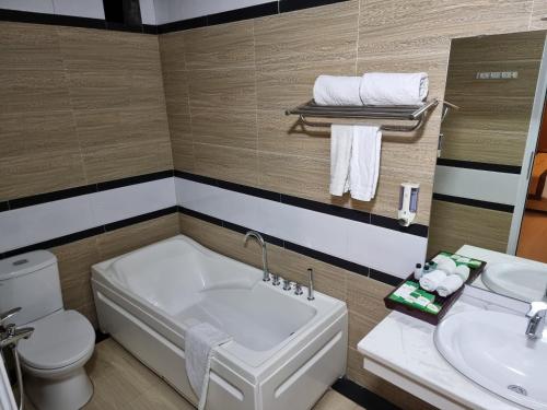 a bathroom with a tub and a toilet and a sink at Ánh Dương Hotel Hải Phòng in An Khê