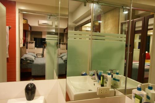 een badkamer met een wastafel en een spiegel bij Luxury Condo at Forbeswood Parklane The Fort BGC in Manilla