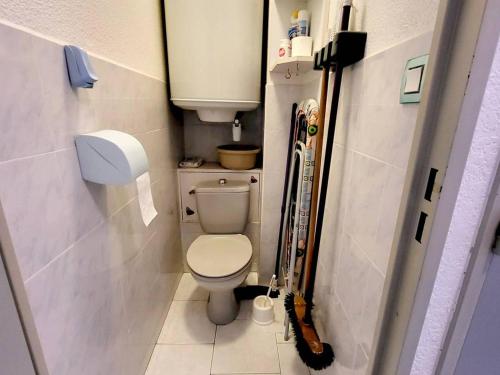 une petite salle de bain avec toilettes et skis dedans dans l'établissement Appartement T3 - Parking - Piscine, Tennis, Proche Plages et Commerces - Six-Fours-les-Plages - FR-1-316-50, à Six-Fours-les-Plages