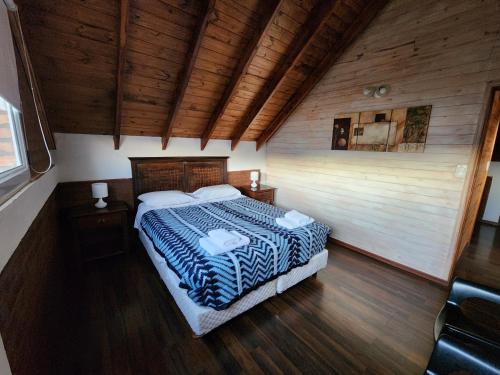 una camera da letto con letto in una camera in legno di Valle Florido 1 a Trevelin