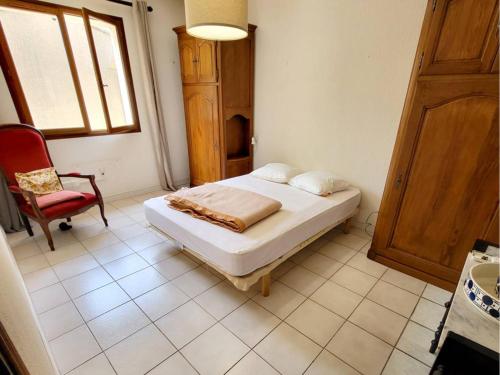 une chambre avec un lit, une chaise et une fenêtre dans l'établissement Villa T4 climatisée, rez-de-jardin, parking privé, proche plage et commerces - FR-1-316-182, à Six-Fours-les-Plages