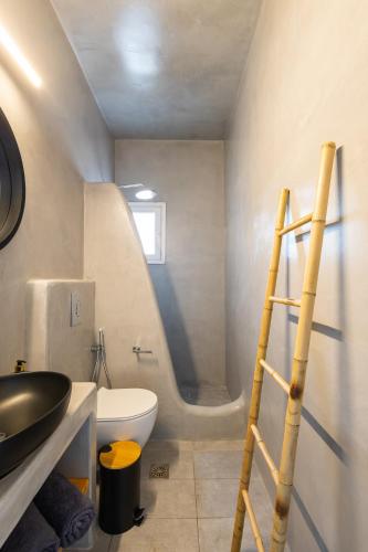a bathroom with a toilet and a sink and a ladder at BlackRock suites in Karterados