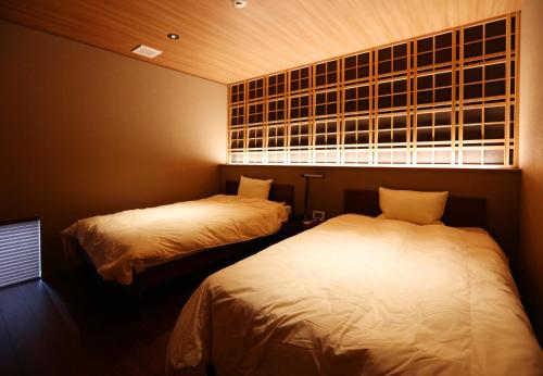 two beds in a small room with a window at yabenomori 