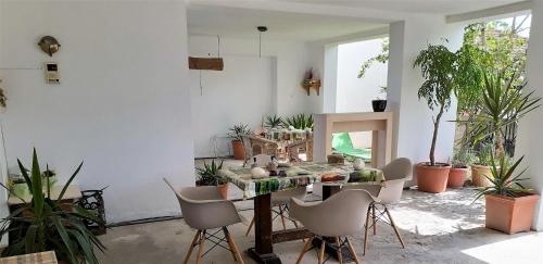 um quarto com uma mesa com cadeiras e plantas em Villa Malena Volos Alykes Beach em Dhimínion