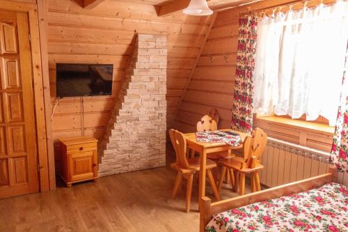 una habitación con mesa y sillas en una cabaña en Willa U Góralki, en Murzasichle