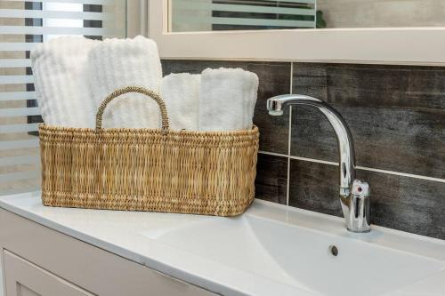 two baskets of towels are sitting on a sink at ג'וליוס סוויטה in Adamit