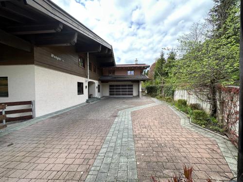 a brick driveway leading to a building with a garage at Haus Wenger Mountain View & Swimming Pool in Kaprun