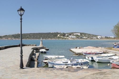 a group of boats are docked at a dock at Cavos Paros Boho Chic sea-view apartment in Aliki, Paros in Aliki
