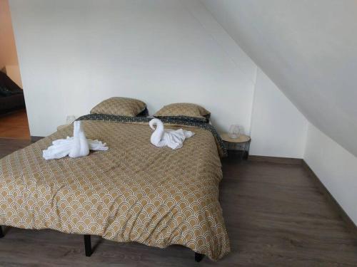 Un dormitorio con una cama con dos cisnes. en Jolie maison entre Terre et Mer, en Lithaire