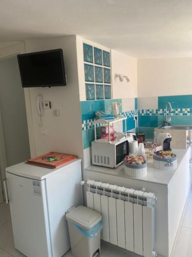 una cucina con piano di lavoro e forno a microonde di LAGUNA BLU Camera TRAMONTO con terrazza panoramica in comune a Chioggia