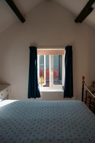1 dormitorio con cama y ventana en Cwm Lodge, an idyllic retreat in the heart of Herefordshire! en Hereford