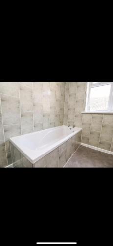 a white bath tub in a bathroom with a window at The Oxfordshire in Blackpool