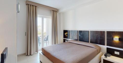um quarto de hotel com uma cama e uma janela em Monte Sarago Villas em Ostuni