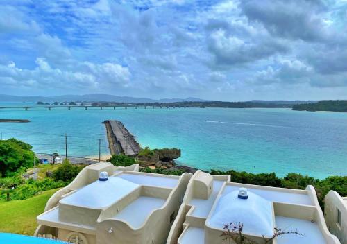 a view of the ocean from a resort with white chairs at Yuki Suite Kourijima in Nakijin