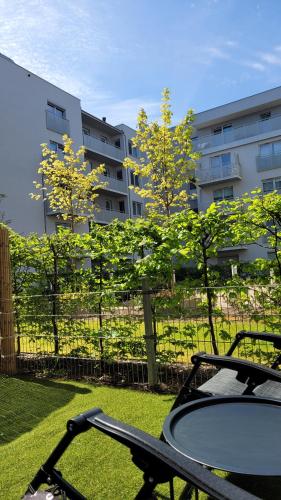 una mesa en un patio con un edificio al fondo en Green Terrace Family Apartment, en Wroclaw