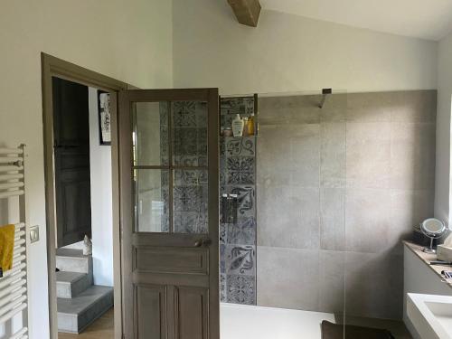 une salle de bain avec une douche avec une porte vitrée dans l'établissement Mas des Grands Chenes Uzes a 8km, à Aubussargues