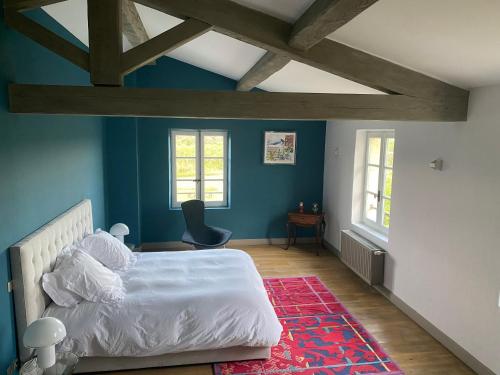 - une chambre avec un lit blanc et des murs bleus dans l'établissement Mas des Grands Chenes Uzes a 8km, à Aubussargues