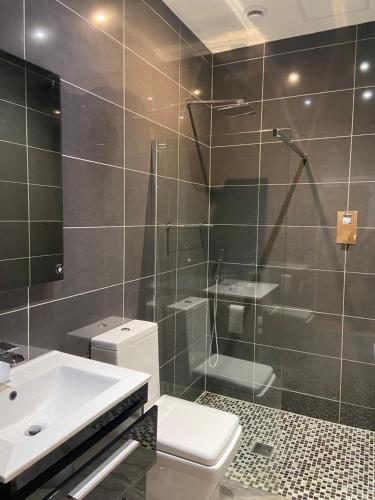 uma casa de banho com um WC, um lavatório e um chuveiro em Halvard Apartments at Castletown em Castletown