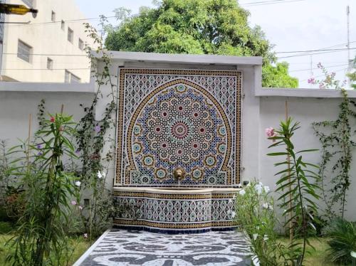 a large rug on a wall in a garden at La Villa Saint Jean in Cotonou