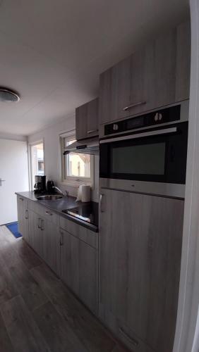 a kitchen with a stove and a sink in it at Vakantiepark duinzicht in Koudekerke