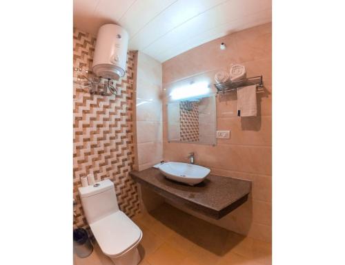 a bathroom with a sink and a toilet at Hotel Aerodyo Inn, Laxmeshwar in Almora