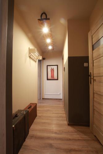 a hallway with a door and a painting on the wall at Apartament w sercu Karkonoszy in Jelenia Góra