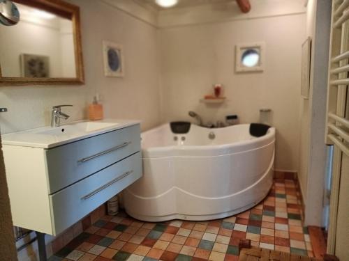 a bathroom with a large tub and a sink at Fæbrogaard Apartment in Skærbæk