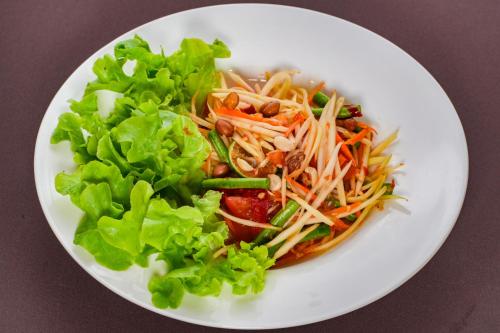 a plate of food with a salad on a table at มนต์เมืองเชียงใหม่ รีสอร์ต Monmuang Chiangmai Resort in Hang Dong