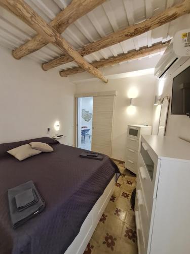 a bedroom with a large bed and a kitchen at Tra i Mari in Trapani