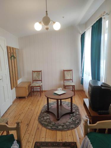 - un salon avec une table et une télévision dans l'établissement Tilžė, à Šiauliai