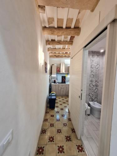 a hallway with a bathroom with a toilet and a tile floor at Tra i Mari in Trapani