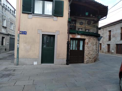 un edificio con dos puertas verdes en una calle en Ático Rosita en Camino de Santiago, en Xinzo de Limia