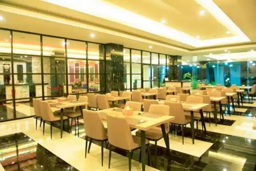 un ristorante con tavoli e sedie in un edificio di Hotel Simfony Alor a Kalabahi