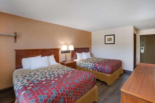 a hotel room with two beds and a table at Rodeway Inn in Colorado Springs