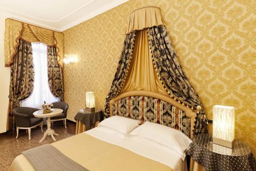 une chambre d'hôtel avec un lit, une table et des chaises dans l'établissement Ca' Bragadin e Carabba, à Venise