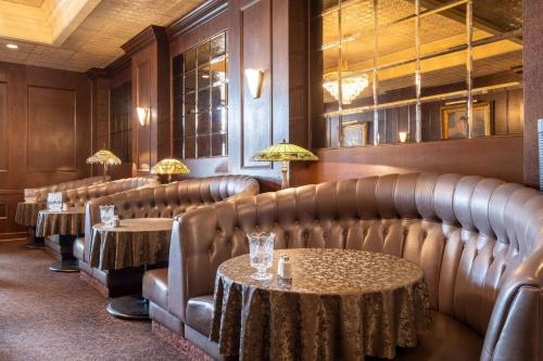 a restaurant with leather chairs and tables with lamps at Gilmore Hotel, Trademark Collection by Wyndham in Ketchikan