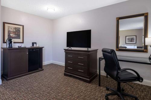a room with a desk with a television and a chair at Ramada by Wyndham Juneau in Juneau