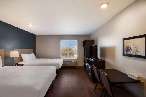 una camera d'albergo con due letti e una finestra di WoodSpring Suites Orlando West - Clermont a Clermont